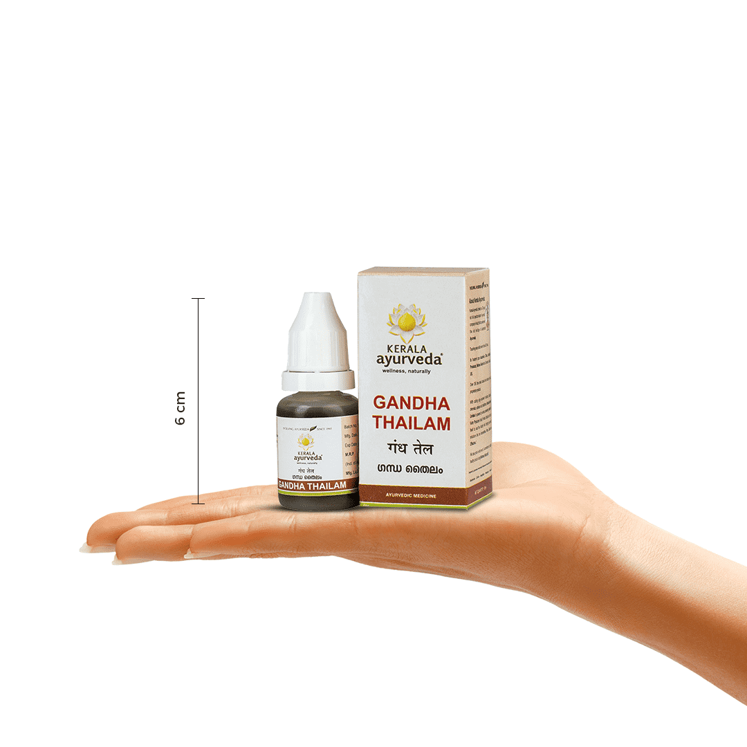 A hand holding a bottle of Kerala Ayurveda Gandha Thailam next to its product box, with a measurement indicator showing its height as 6 cm. – Kerala Ayurveda India