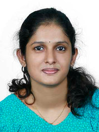 A young woman with dark hair and a blue top, posing against a white background.