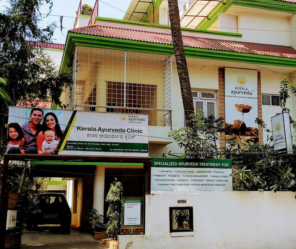 Entrance of Kerala Ayurveda Clinic with signage and family photo on the wall.